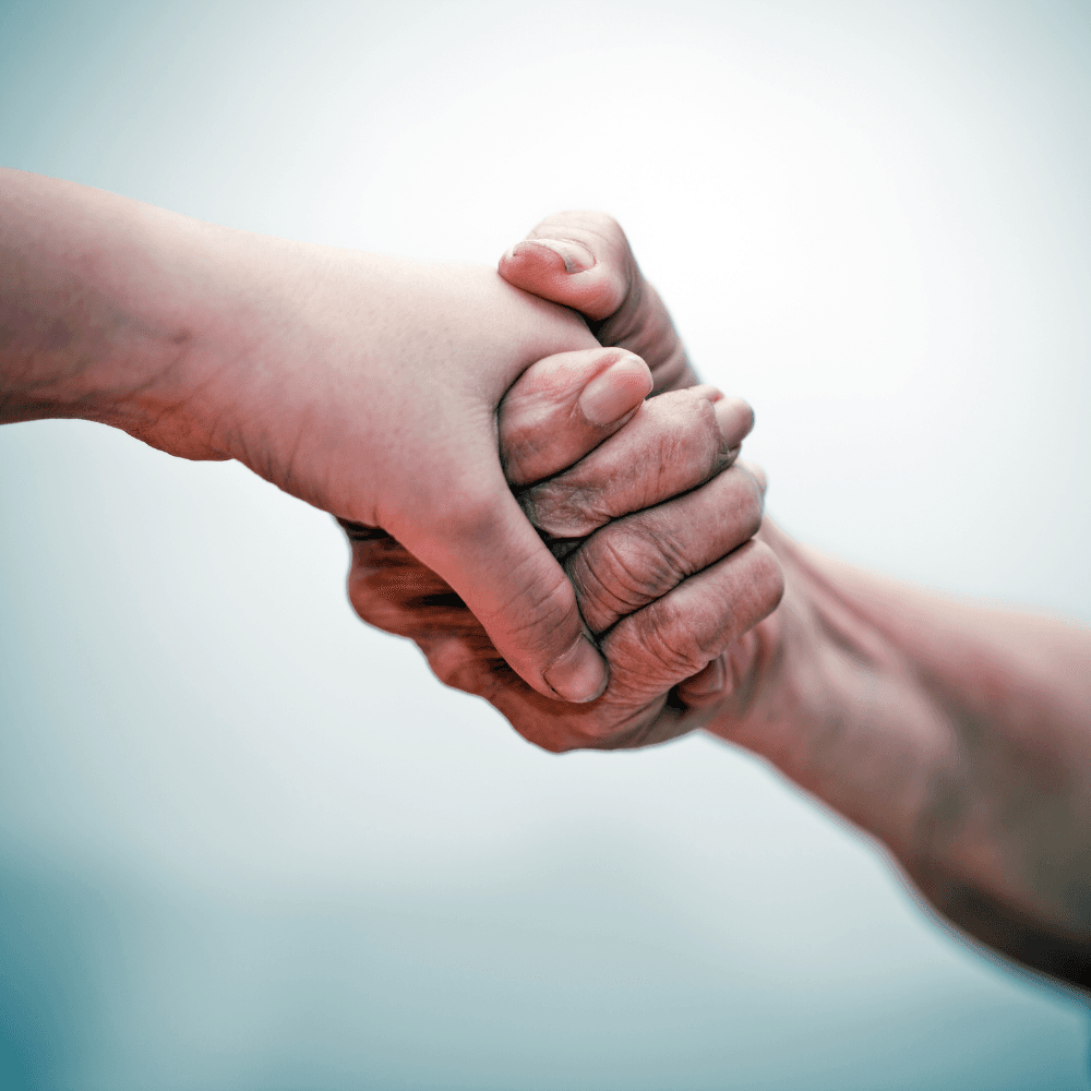 A younger hand clasping an older person's hand