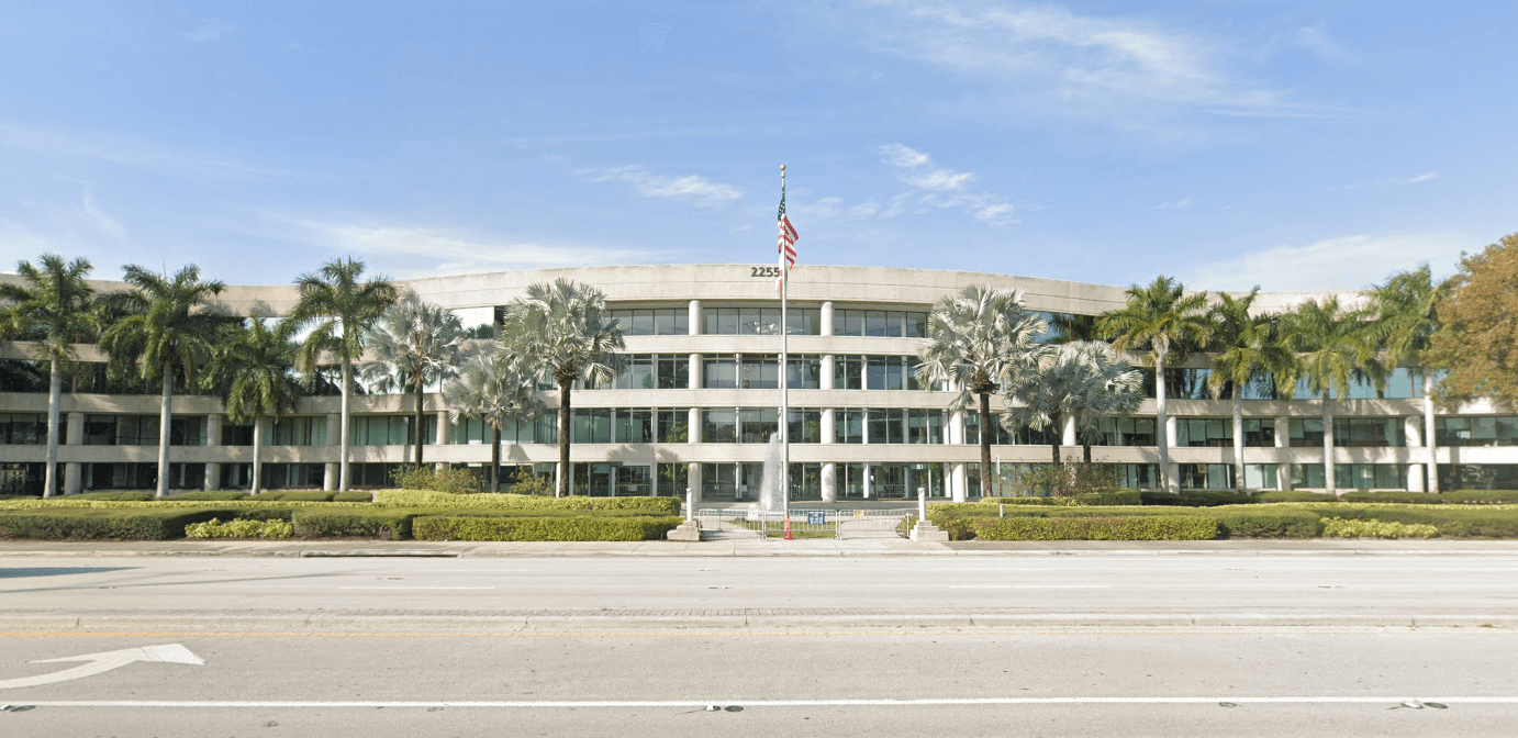 The Royal Oaks Home Care office building on Palmetto Park Road in Boca Raton, lined with palm trees
