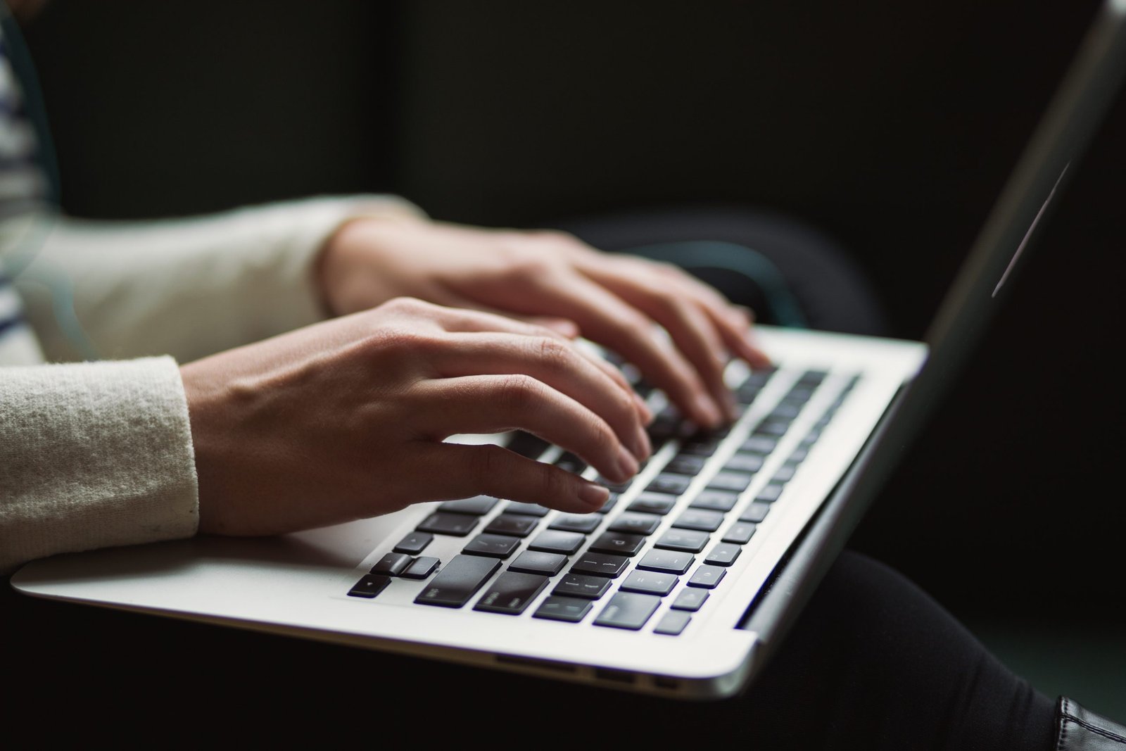 zoom in on hands typing on a laptop's keyboard